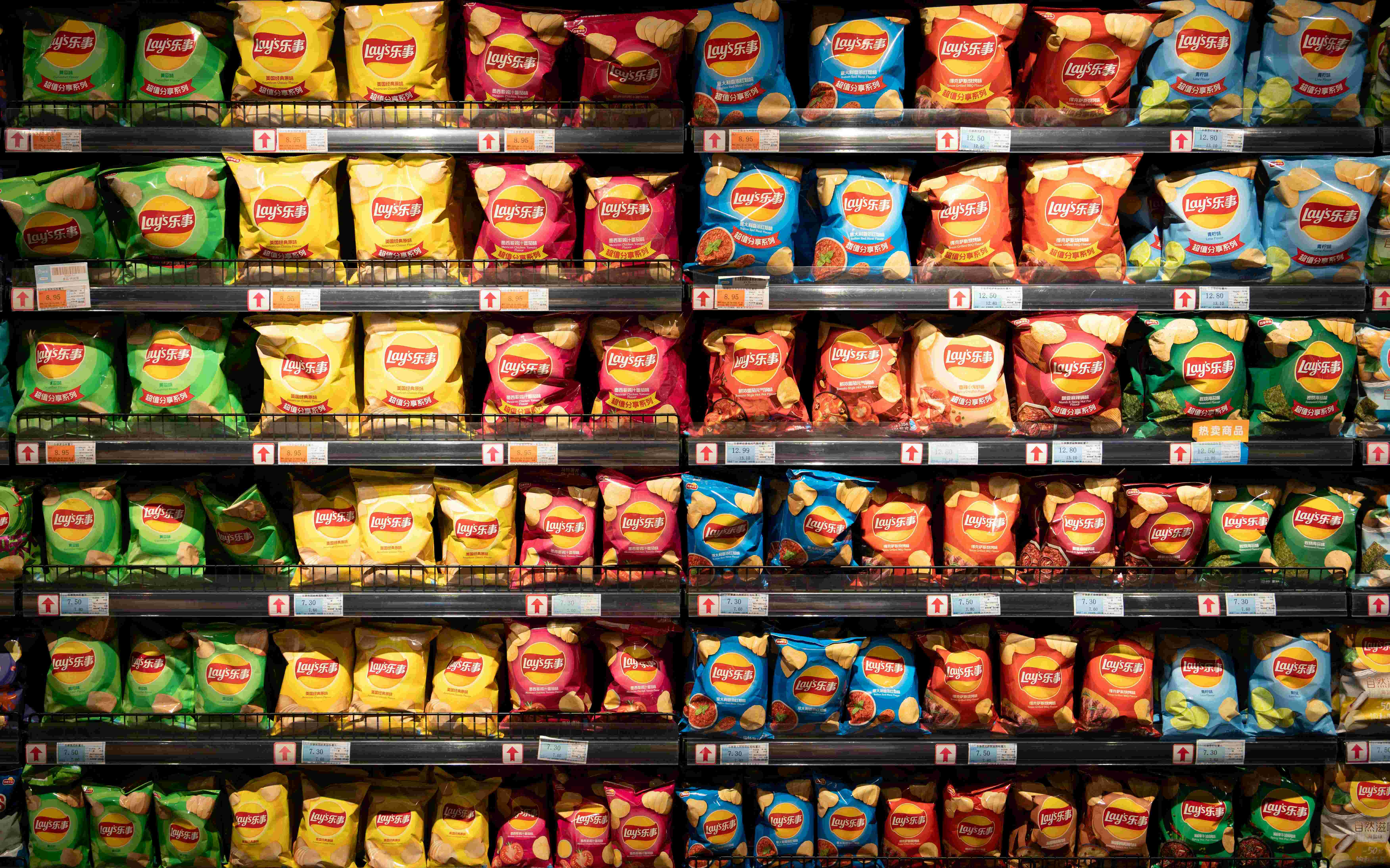 Regály plné balíčků chipsů – Lays